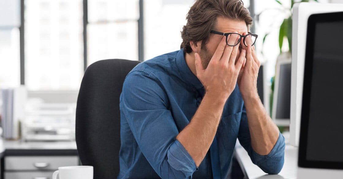 Digital professional experiencing eye strain at computer workstation