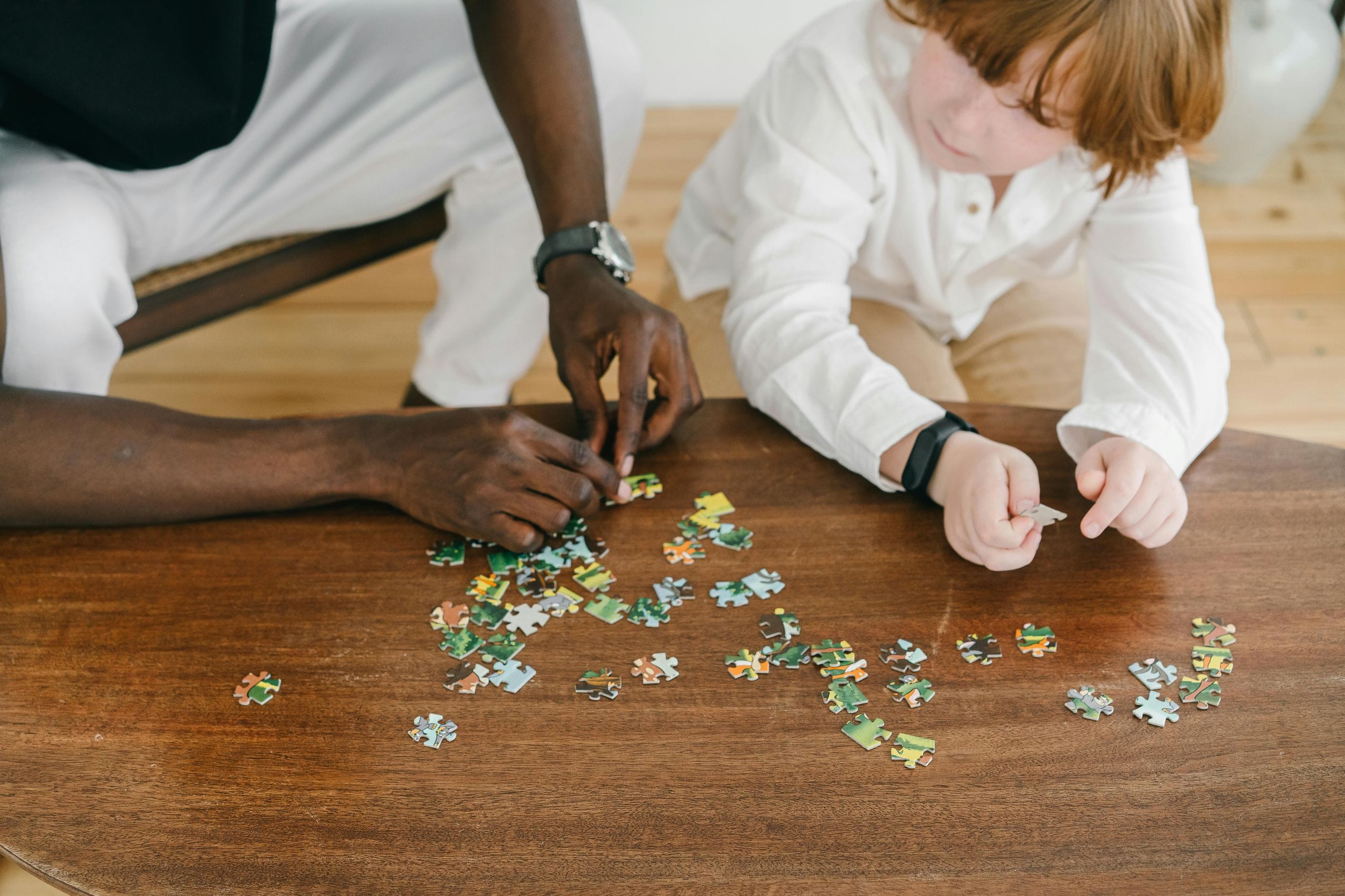 Parent and child working together on a jigsaw puzzle as a family activity