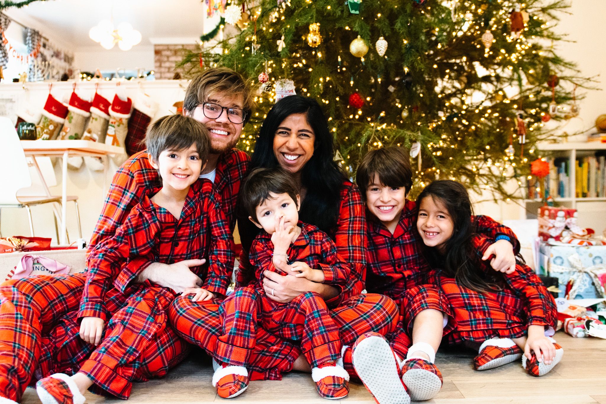 Family wearing matching holiday Christmas pajamas for a coordinated photo