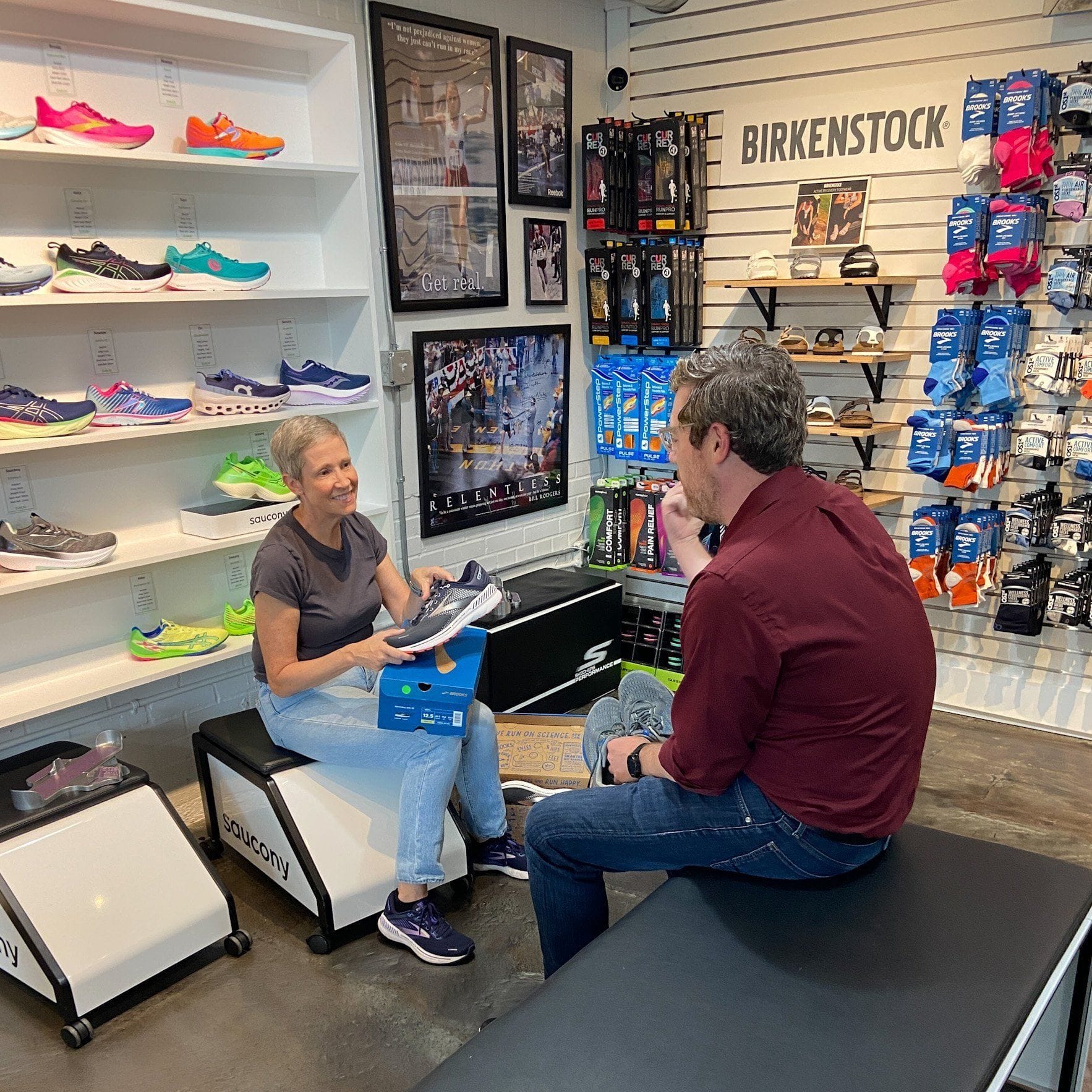 Expert running shoe fitting service with staff helping customer choose correct shoes