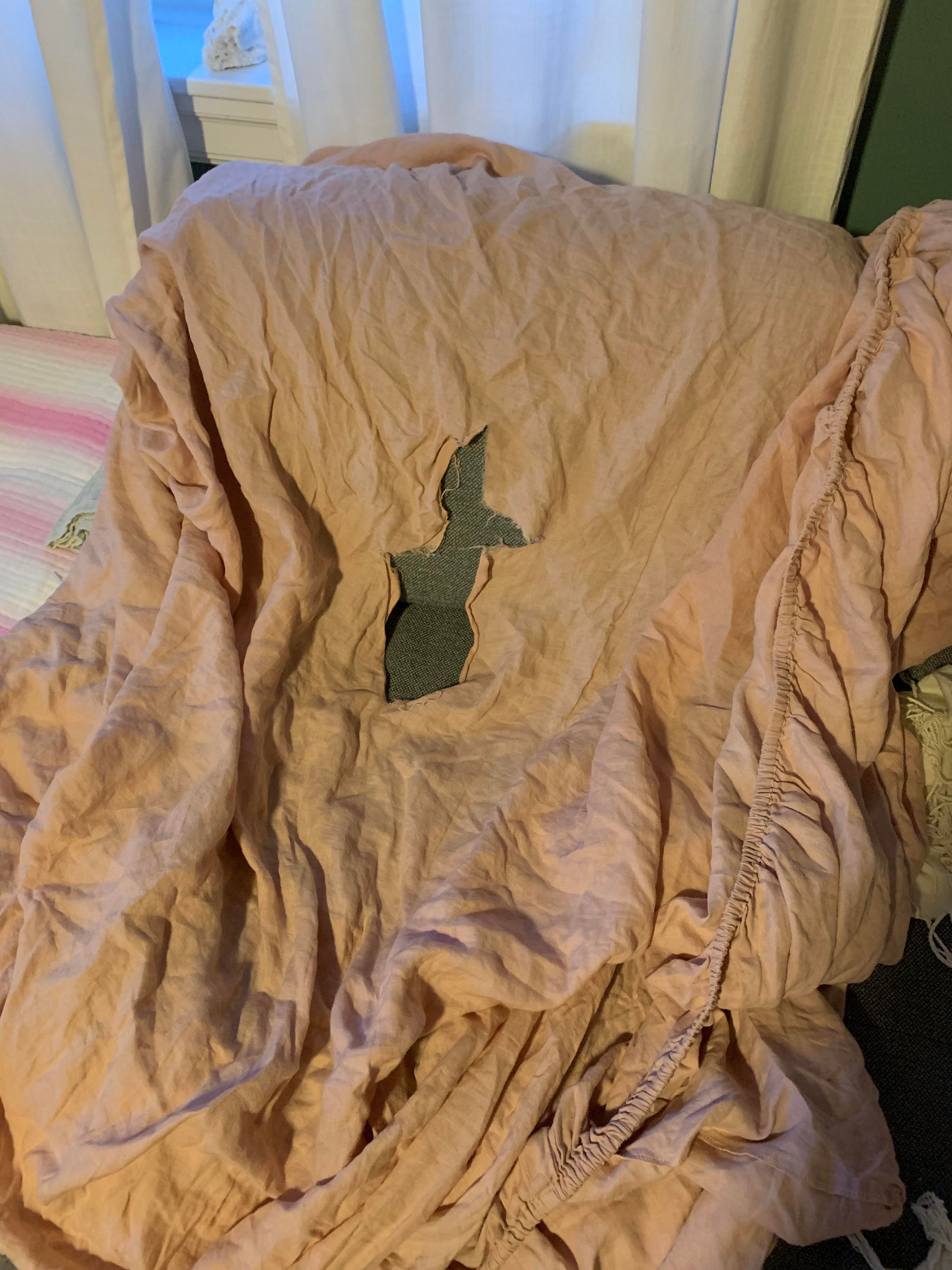 Torn linen sheet showing premature fabric failure and thinning material