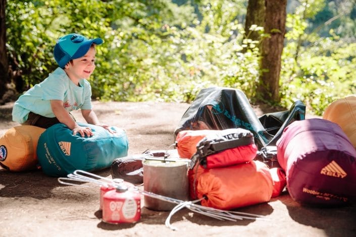 Family camping gear including tent sleeping bags and outdoor supplies