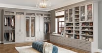 California Closets custom walk-in closet design with elegant white cabinetry and premium hardware