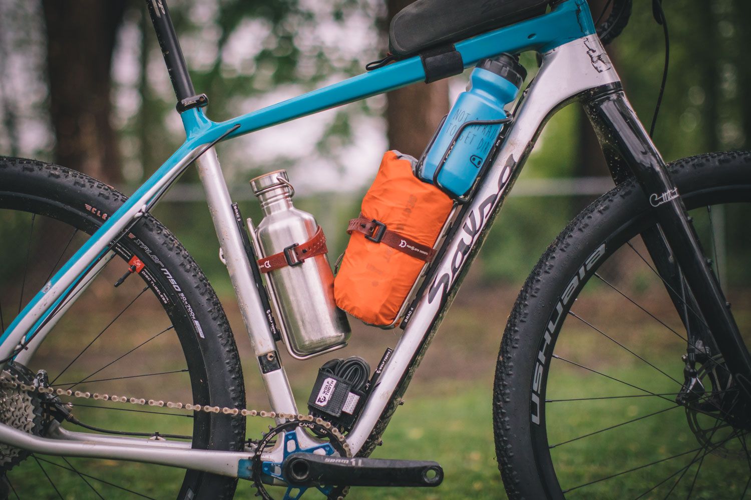Wolf Tooth B-RAD mounting system installed on a bikepacking setup showing versatile bottle cage mounting