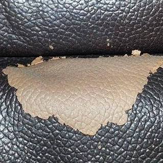 Close-up of peeling PU faux leather handbag surface showing typical flaking material failure