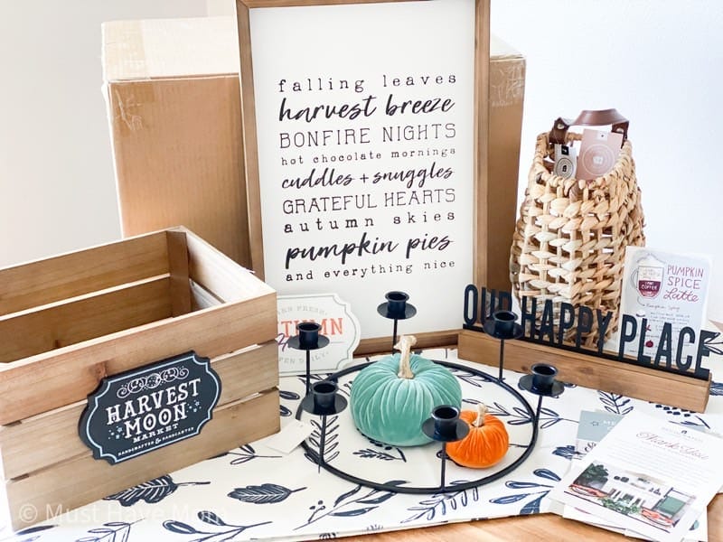 Quarterly home decor subscription box unboxing showing seasonal items like candles wood bowls and faux florals