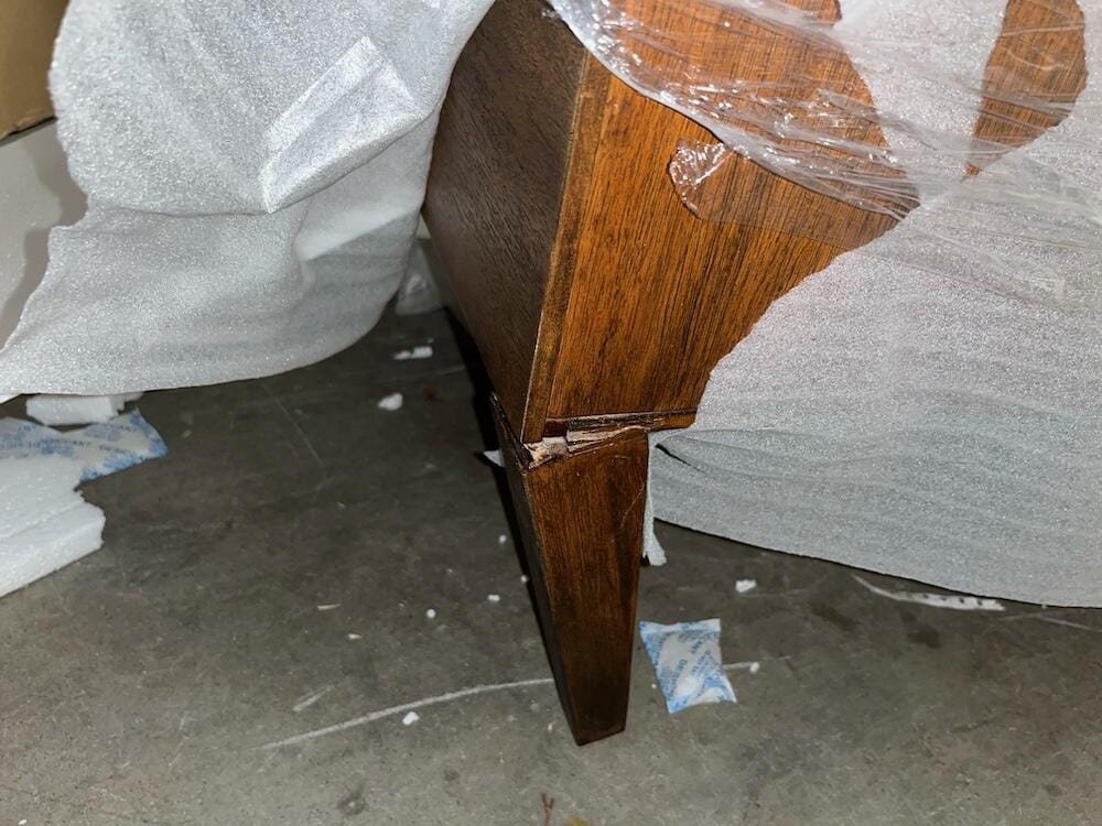 Damaged online furniture delivery box illustrating the risks of buying sofas direct-to-consumer