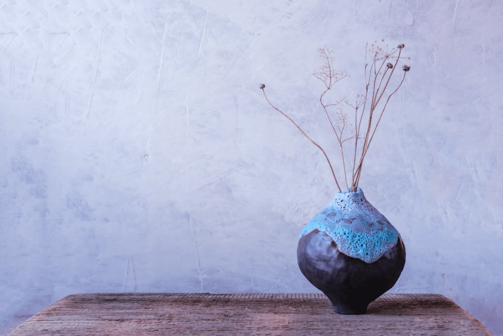 Wabi-sabi minimalist Japanese ceramic vase with natural earthy aesthetic on wooden surface