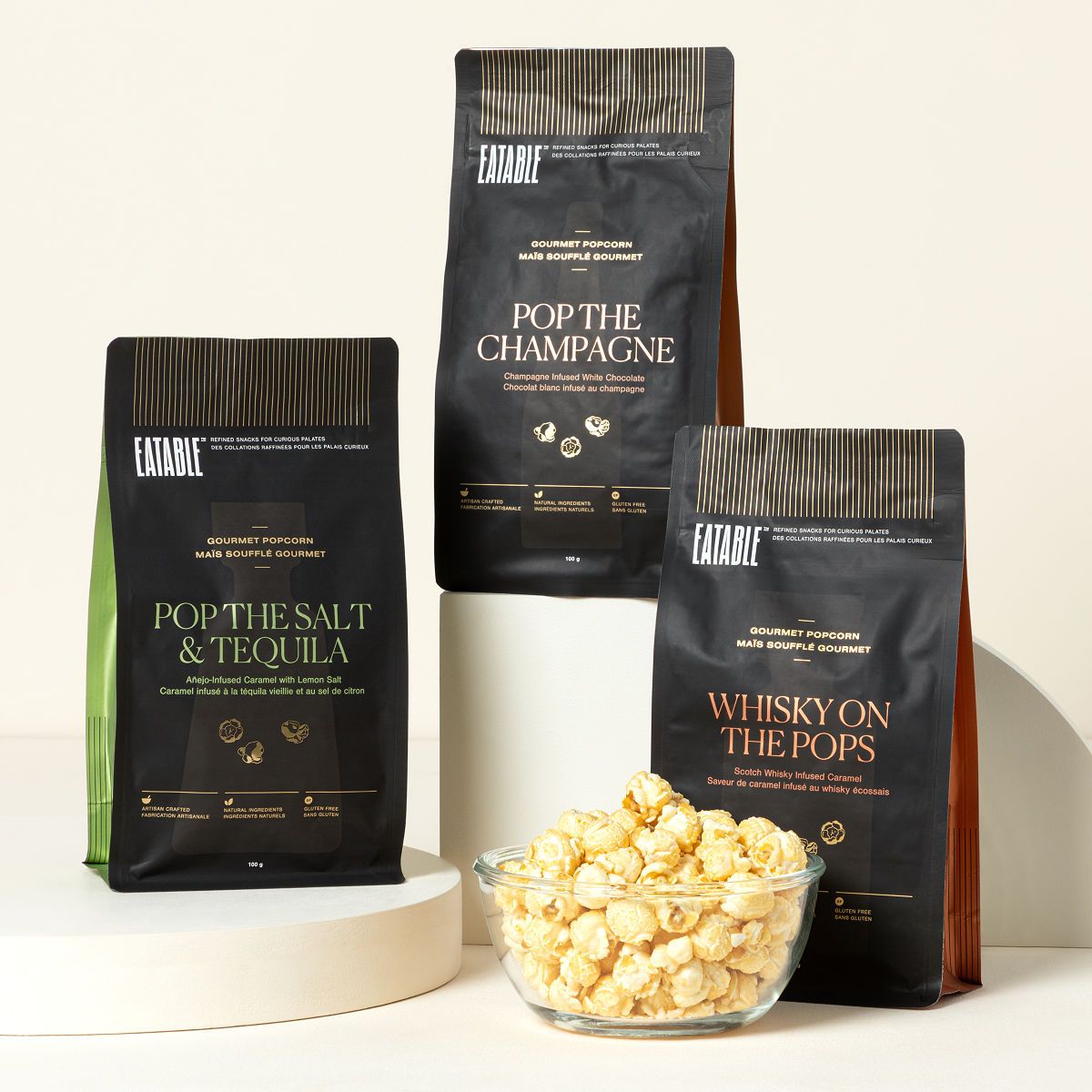 Eatable alcohol-infused gourmet popcorn trio featuring champagne whisky and merlot flavors in elegant gift packaging