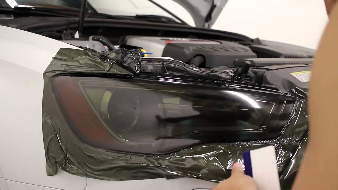 DIY headlight tinting vinyl overlay installation process on modern vehicle headlight assembly