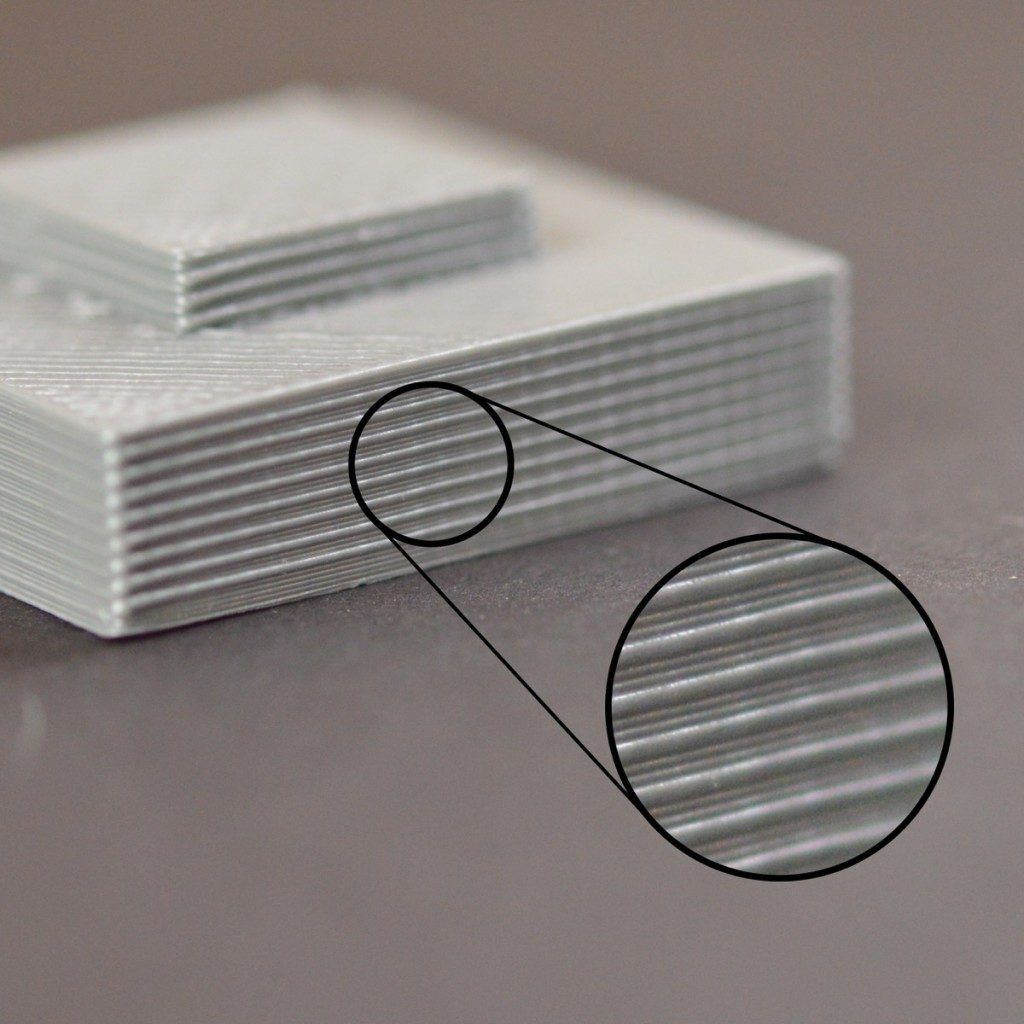 Close-up of 3D printed PLA plastic showing visible FDM layer lines on finished surface