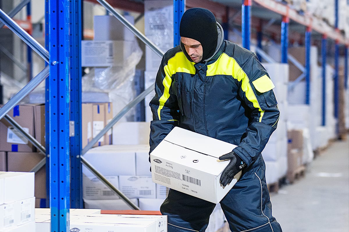 Freezer warehouse workers wearing cold storage PPE inside refrigerated cold chain environment