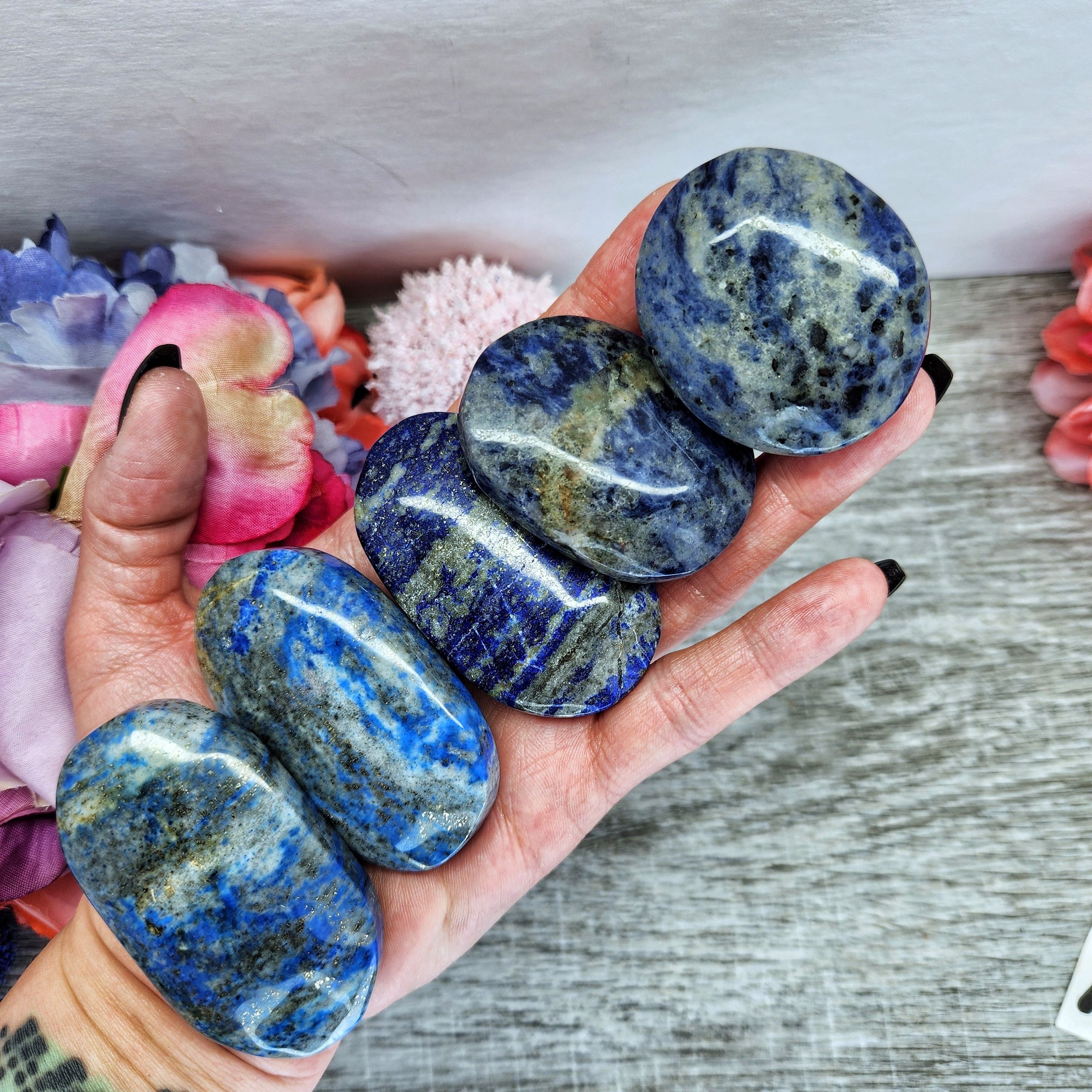 Lapis lazuli palm stone with sodalite and pyrite inclusions showing deep blue polished crystal carving