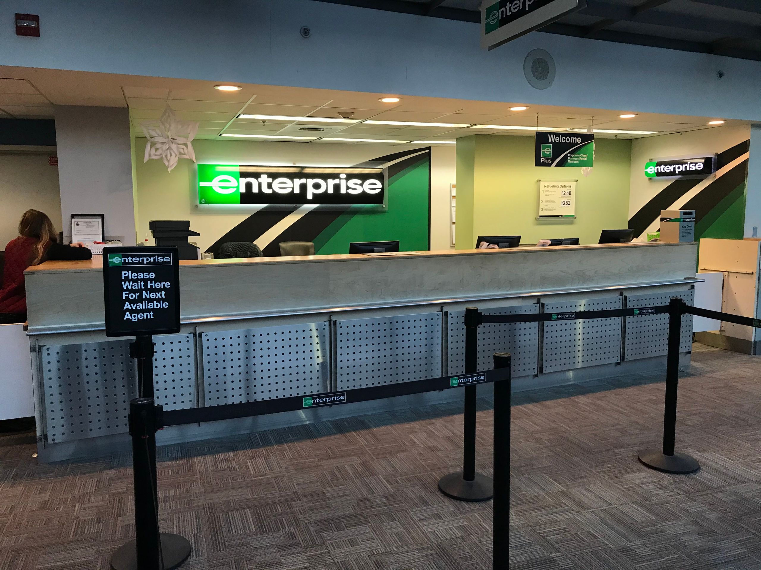 Enterprise rent a car airport counter showing rental service desk with staff area
