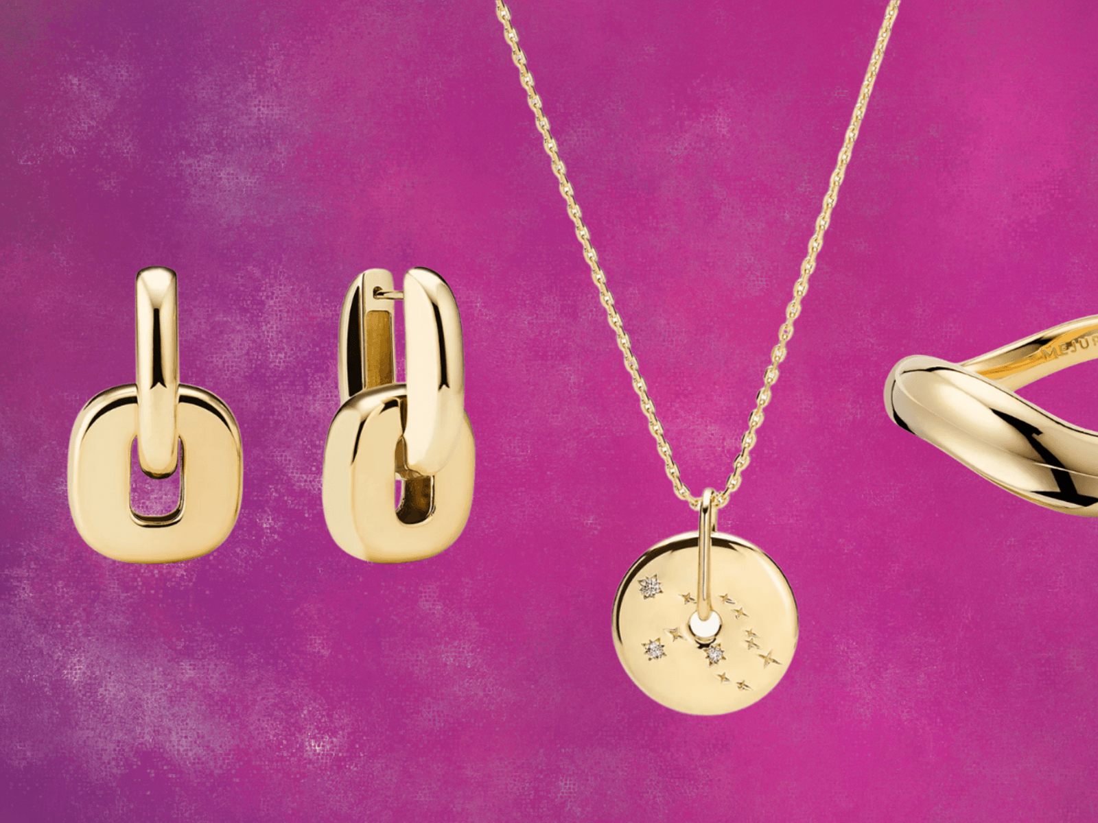 Mejuri gold vermeil jewelry collection displayed on marble surface showing minimalist demi-fine pieces