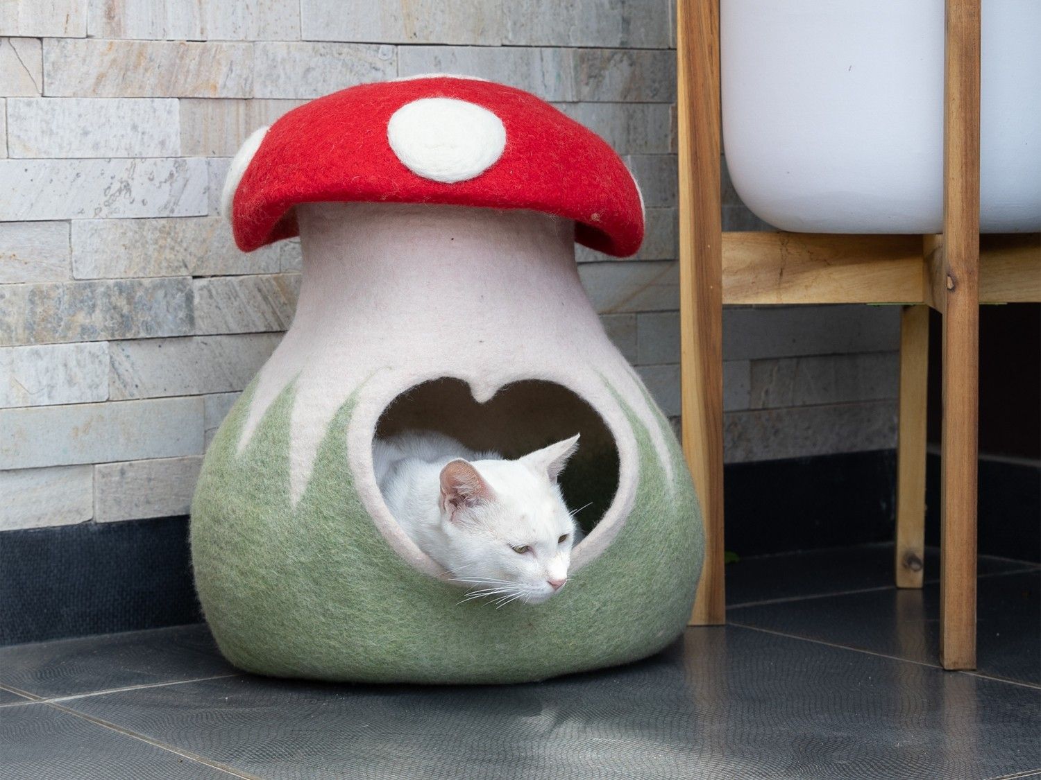 Handmade wool felt mushroom-shaped cat cave in orange and white showing Catcaveco style design