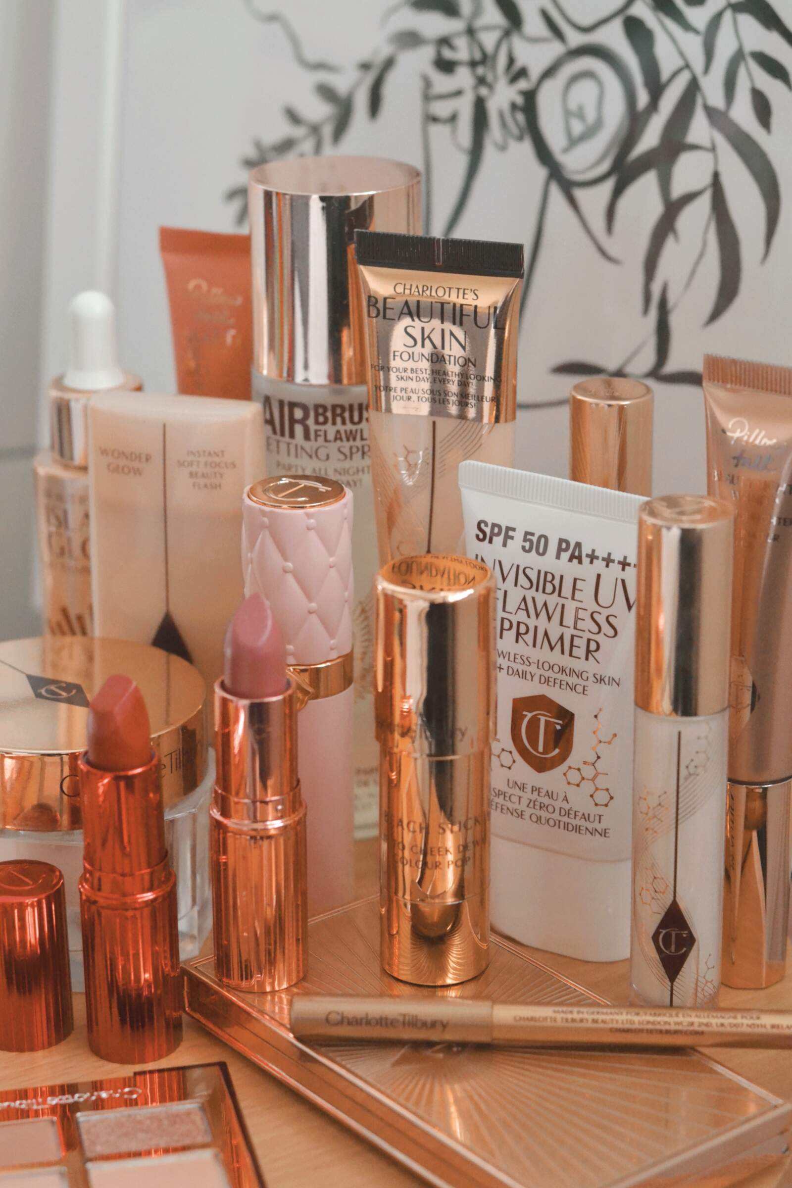Charlotte Tilbury luxury makeup product collection with signature rose-gold packaging on vanity