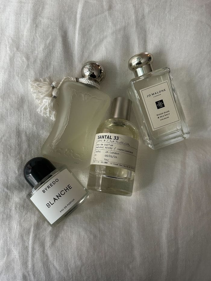 Minimalist clean fragrance perfume bottles arranged on neutral background representing modern non-toxic perfumery