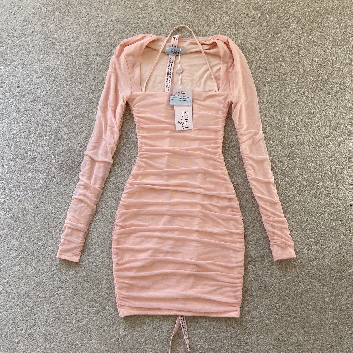 Oh Polly blush pink long sleeve ruched bodycon mini dress showcasing signature compressive fit