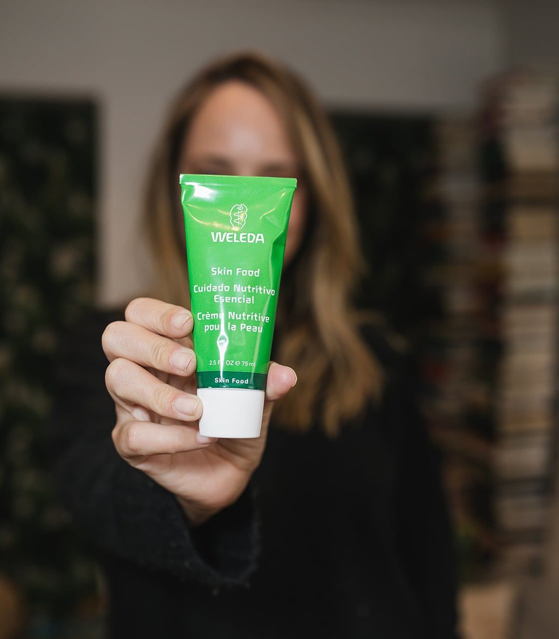 Weleda Skin Food cream squeezed onto fingers showing rich buttery texture for dry skin
