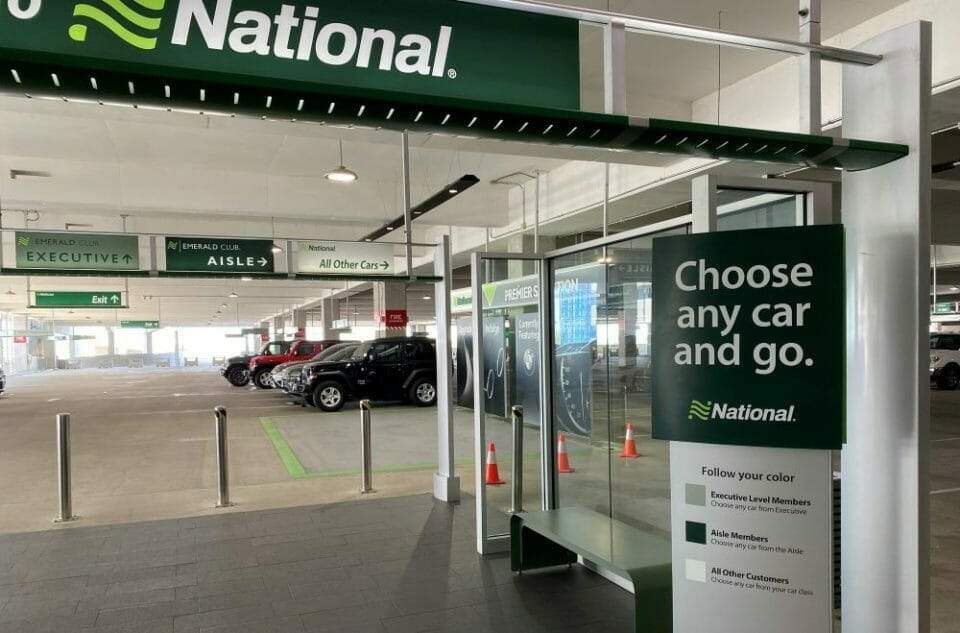 National Emerald Club Aisle pricing breakdown sign showing fees and base rates